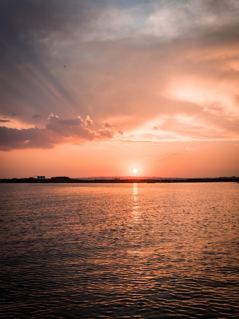 Beautiful vertical shot of a pink sunset over a sea- perfect for mobile wallpaper