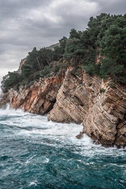 Beautiful view of the Adriatic coast on a cloudy winter day. Near the city of Petrovac, Adriatic coast of Montenegro. vertical image