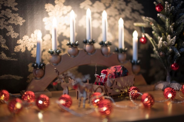 Beautiful view of candles toys a tiny Christmas tree and ornaments on the table