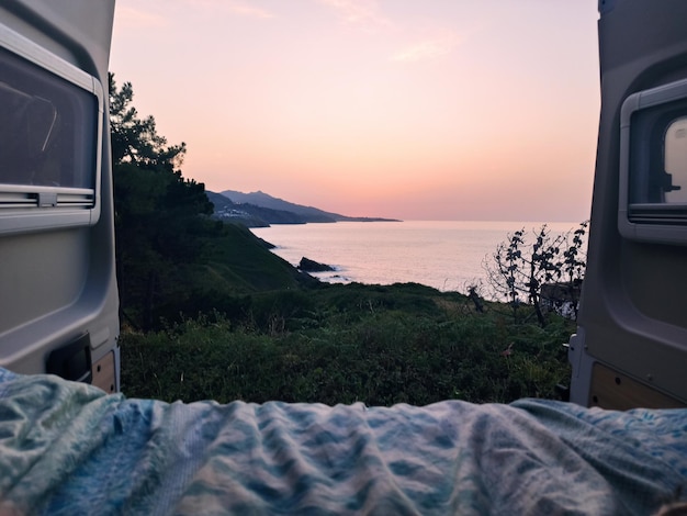 Beautiful view of a coast from the trunk of a campervan - a concept on traveling