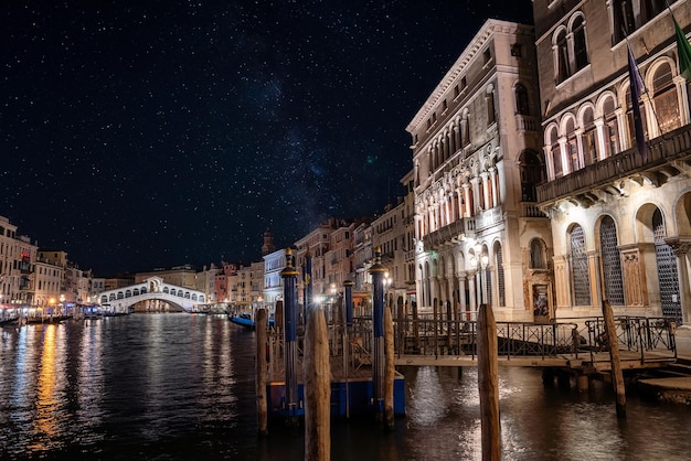Splendida vista del canal grande e del ponte di rialto a venezia di notte con bellissime stelle e la via lattea visibile nel cielo. stile romantico
