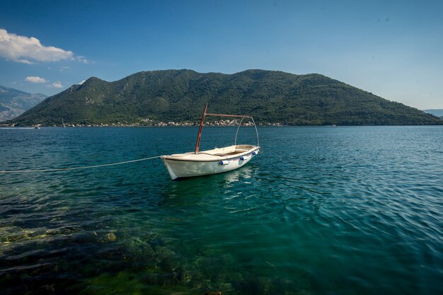 Beautiful view of Kotor bay with moored white wooden rowboat