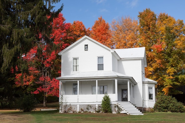 Прекрасный вид на старый белый дом, окруженный деревьями осеннего цвета в штате Мэриленд