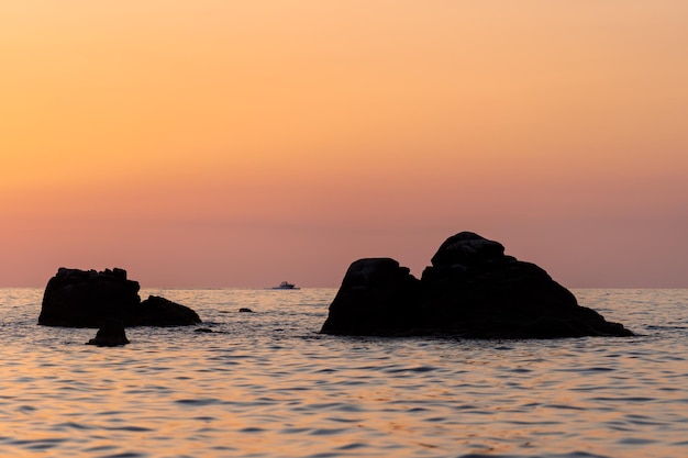 イタリアの岩とオレンジ色の夕日の海の美しい景色 カラフルな日の出の風景