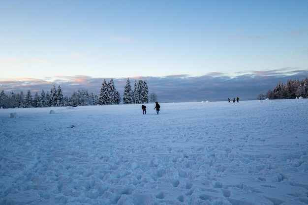 Beautiful view of people playing on a snowy white mountain valley