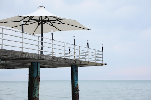 Beautiful view of pier with sun umbrellas near sea