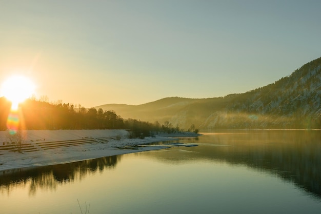 Photo beautiful view of the river surrounded by mountains at sunset