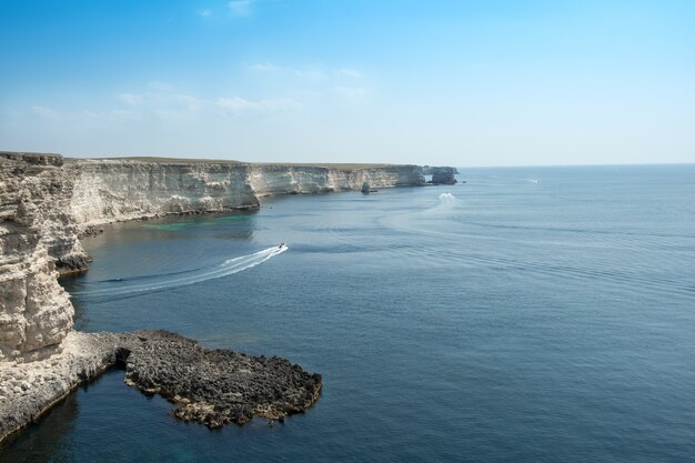 晴れた日に青い海の岩だらけの海岸の美しい景色