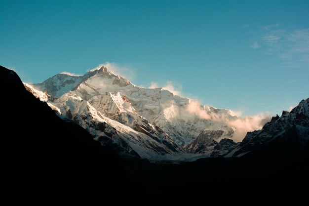 Beautiful view of the rocky and snowy mountain peaks gleaming under the blue sky