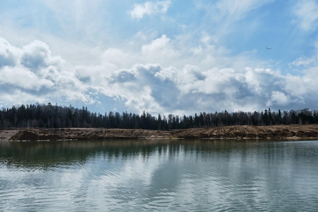 Beautiful view of sand dunes and quarries with water in cloudy sunny weather in spring