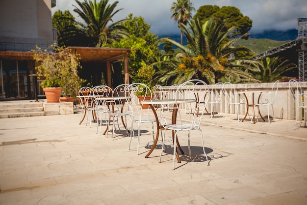 Beautiful view of summer terrace at restaurant surrounded by green palms