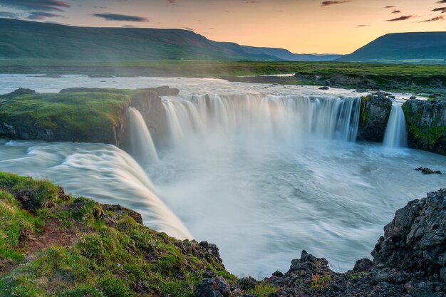 Beautiful view of sunset over powerful Godafoss waterfall flowing from Skjalfandafljot river in summer at Northern of Iceland