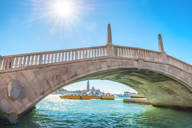 Beautiful view to white bridge over canal and exit to bay Venice Italy