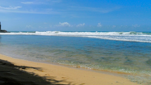 Photo beautiful views of white sand beaches with blue skies at java indonesian republic
