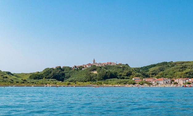 Красивая деревня на зеленом острове. Море, пляж, лето недалеко от Сусака, Хорватия.