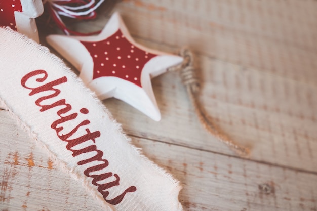 사진 나무 탁자에 있는 아름다운 빈티지 크리스마스 리본과 장난감. 소박한 스타일의 귀엽고 즐거운 장식