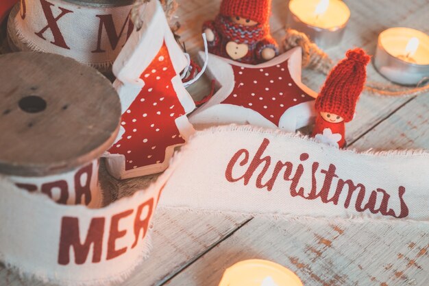 Beautiful vintage christmas ribbons and toys on the wooden table. Cute and pleasant decorations in rustic style