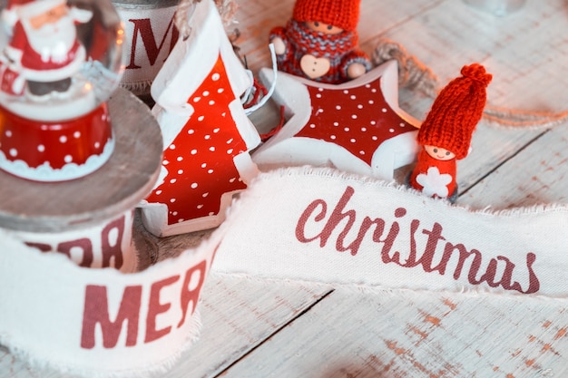 Beautiful vintage christmas ribbons and toys on the wooden table. Cute and pleasant decorations in rustic style