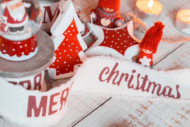 나무 탁자에 있는 아름다운 빈티지 크리스마스 리본과 장난감. 소박한 스타일의 귀엽고 즐거운 장식