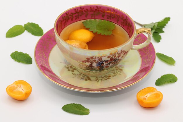 A beautiful vintage porcelain tea cup with a melissa leaf and calamondin fruit halves