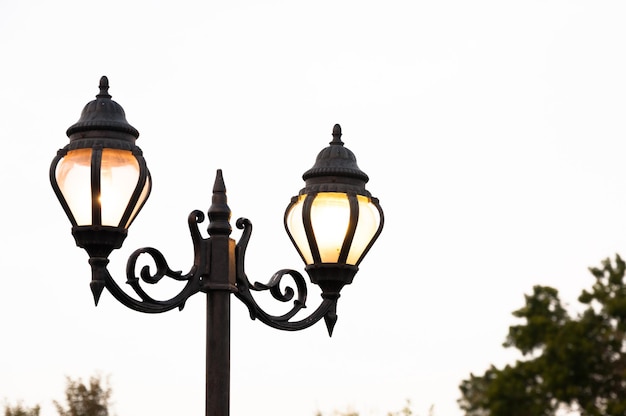 Beautiful vintage Street antique style lamp post with effect of shine from low light of sunset