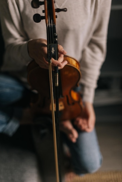 Beautiful violin in the hands of a woman, close-up. Girl is posing with musical instrument.