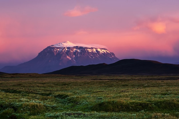 분홍색 일몰 빛으로 눈으로 덮인 아이슬란드의 아름다운 화산
