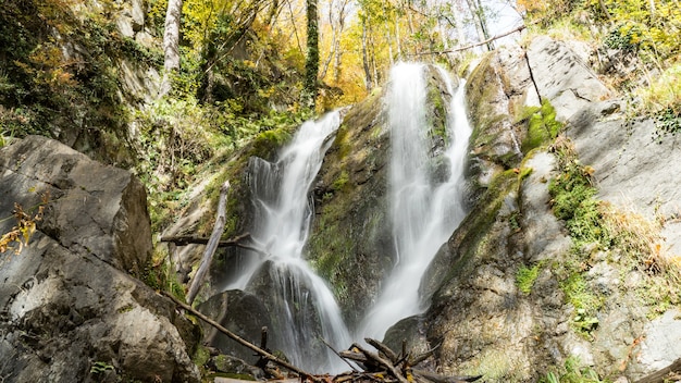 Beautiful waterfall in autumn forest. Krasnaya Polyana, Sochi, Russia.