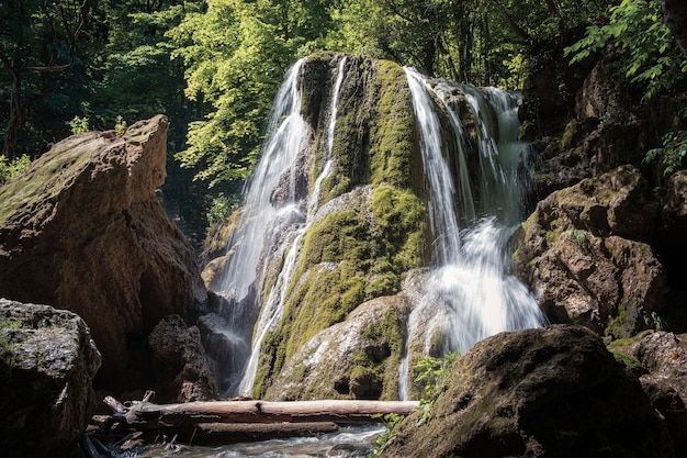 A beautiful waterfall deep in the tropical forest, steep mountain adventure in the rainforest. waterfall silver stream after the collapse of the visor, Crimea, Russia