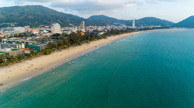 Beautiful wave crashing on sandy shore at patong beach in phuket thailand, aerial view