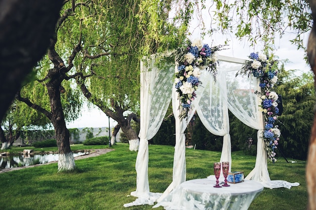 Beautiful wedding arch and table in the nature. Wedding decorations.