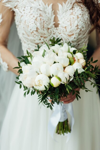 Beautiful wedding bouquet of flowers in hands of the bride