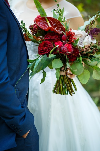 新婚夫婦の手に花の美しいウェディングブーケ