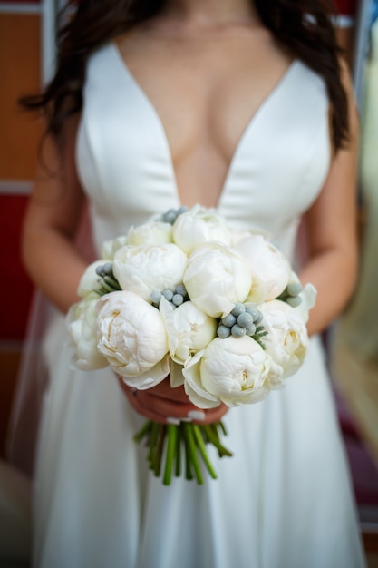 Beautiful wedding bouquet of flowers in the hands of the newlyweds