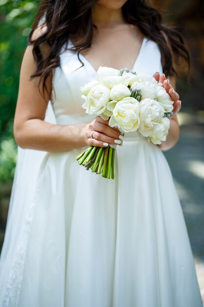 Beautiful wedding bouquet of flowers in the hands of the newlyweds