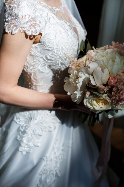 Beautiful wedding bouquet of flowers in the hands of the newlyweds