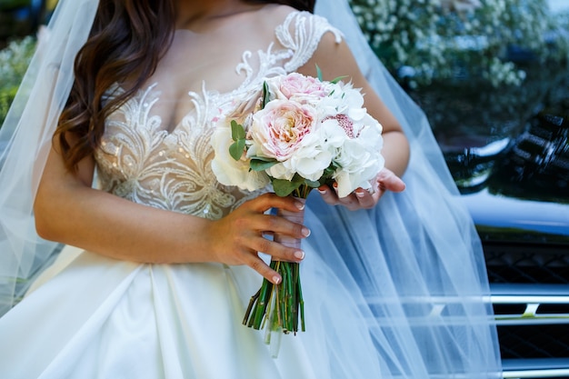 Красивый свадебный букет цветов в руках молодоженов