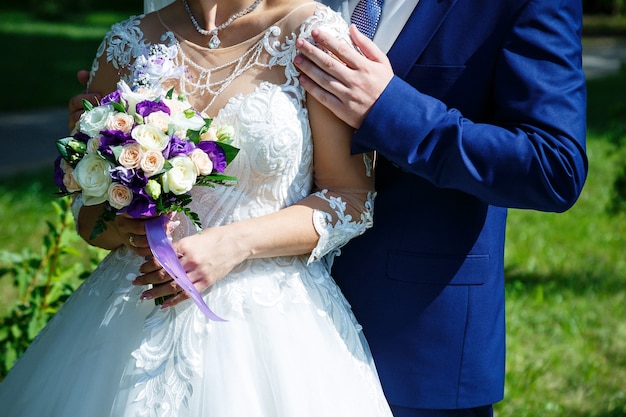 新婚夫婦の手に花の美しいウェディングブーケ