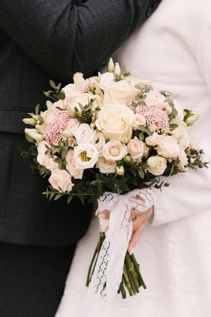 Beautiful wedding bouquet in the hands of the bride