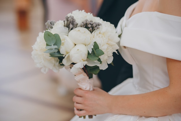 Beautiful wedding bouquet in hands of the bride