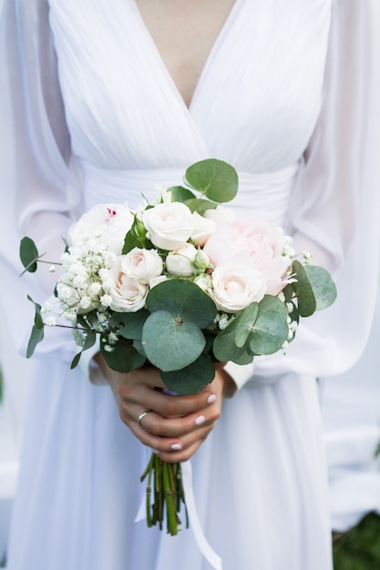 Beautiful wedding bouquet in the hands of the bride