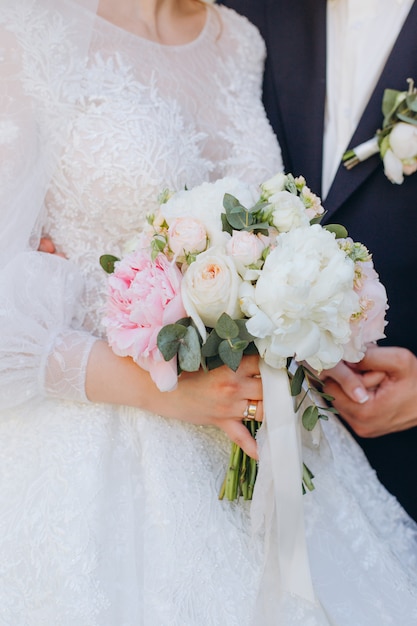 Beautiful wedding bouquet in hands of the bride