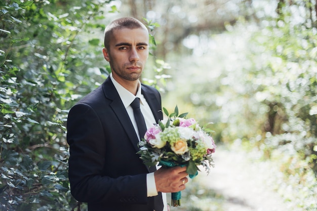 Beautiful wedding bouquet in hands of the groom