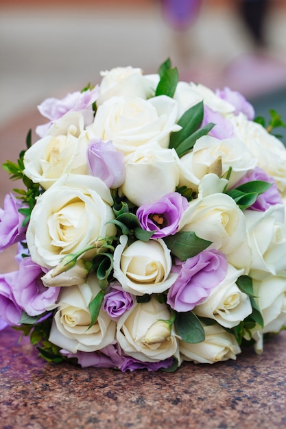 Beautiful wedding bouquet of natural flowers on a blurred background lies on granite