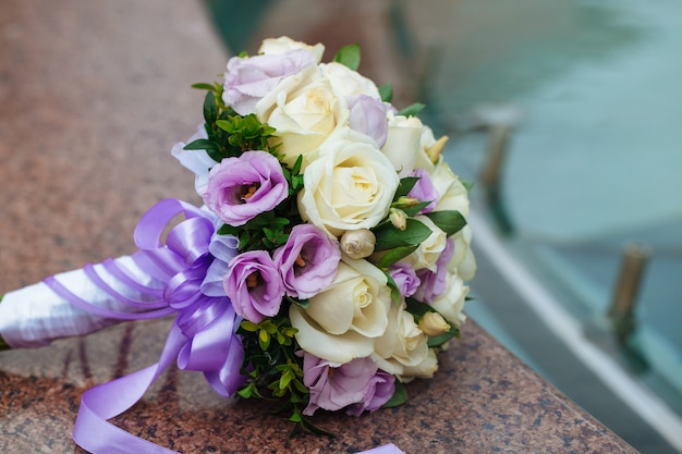 Photo beautiful wedding bouquet of natural flowers on a blurred background lies on granite