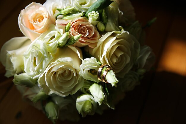 Beautiful wedding bouquet Roses in pastel colors Bridal flowers Golden rings for couple