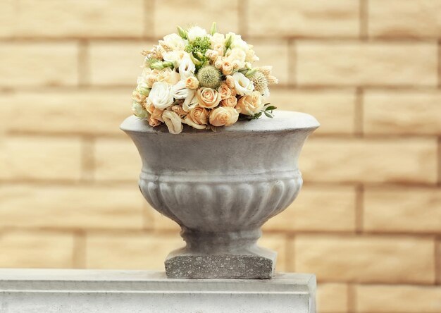 Beautiful wedding bouquet in stone vase outdoors