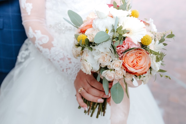 Beautiful wedding bouquet with red, pink and white flowers, roses and eucalyptus, peonies, calla lilies