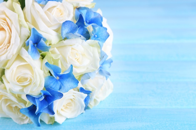 푸른 나무 테이블에 장미가 있는 아름다운 웨딩 부케