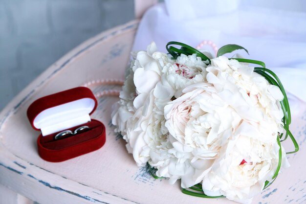 Foto bellissimo bouquet da sposa sulla sedia di legno su sfondo chiaro